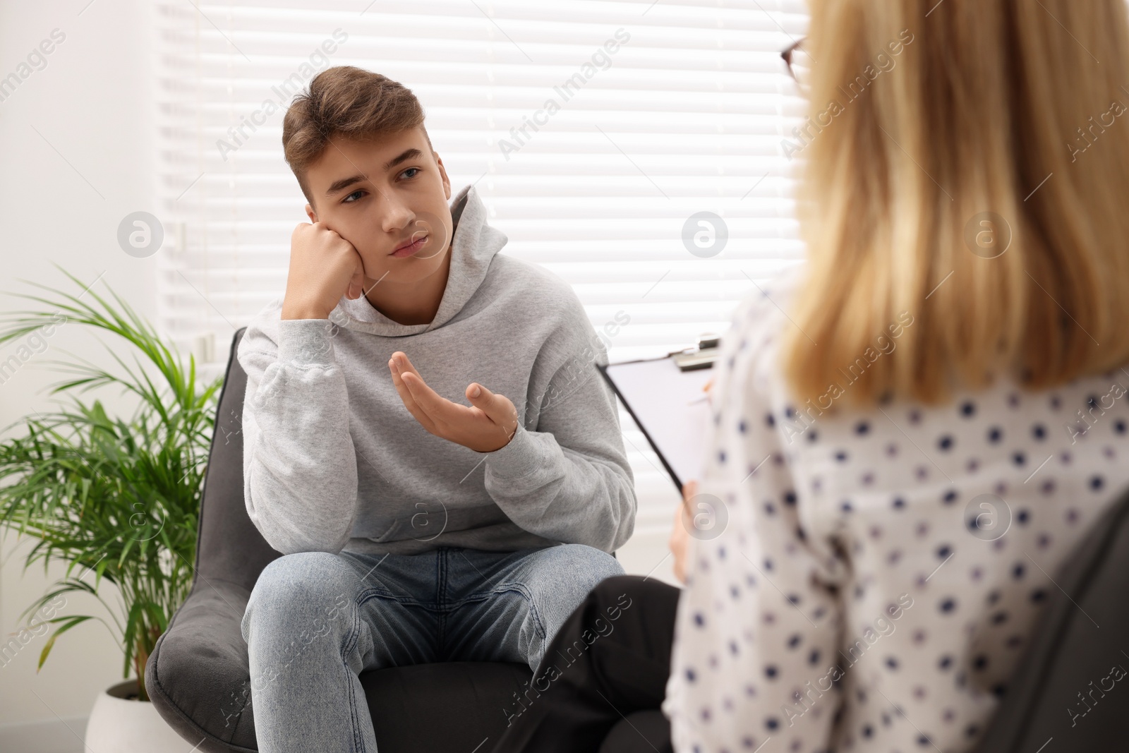 Photo of Psychologist working with teenage boy in office