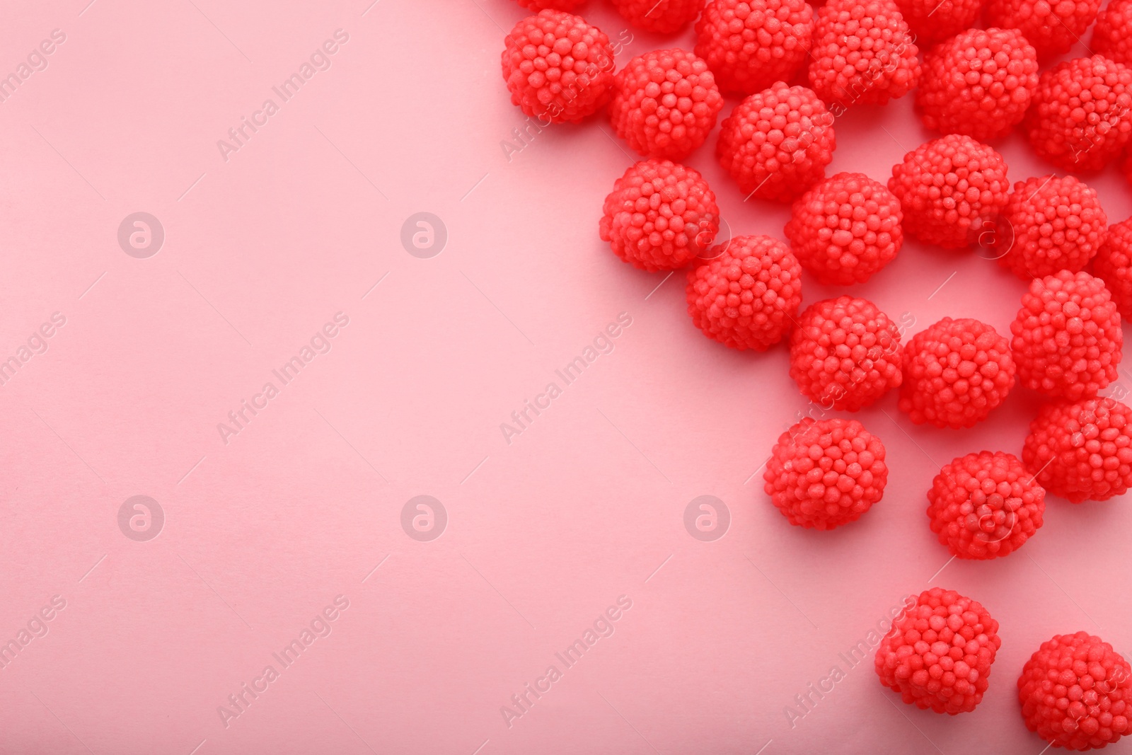 Photo of Delicious gummy raspberry candies on pink background, flat lay. Space for text