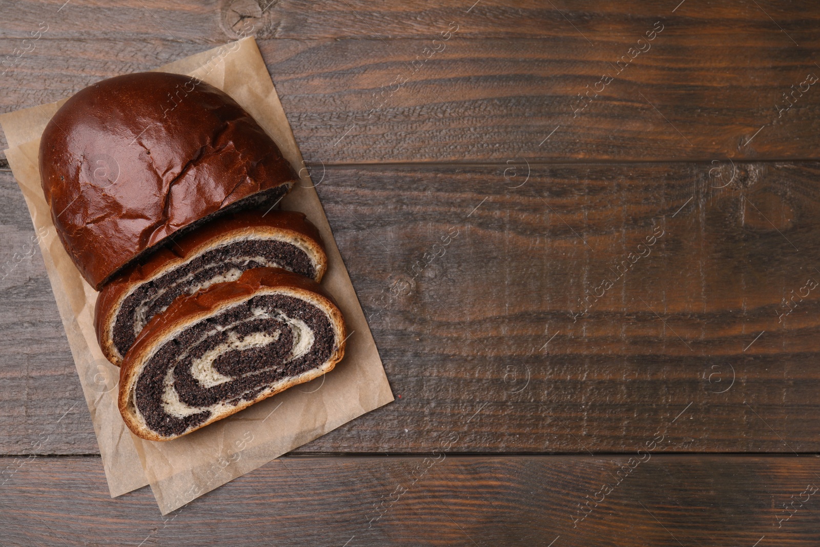 Photo of Cut poppy seed roll on wooden table, top view with space for text. Tasty cake