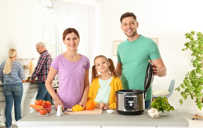 Happy family preparing food with modern multi cooker in kitchen