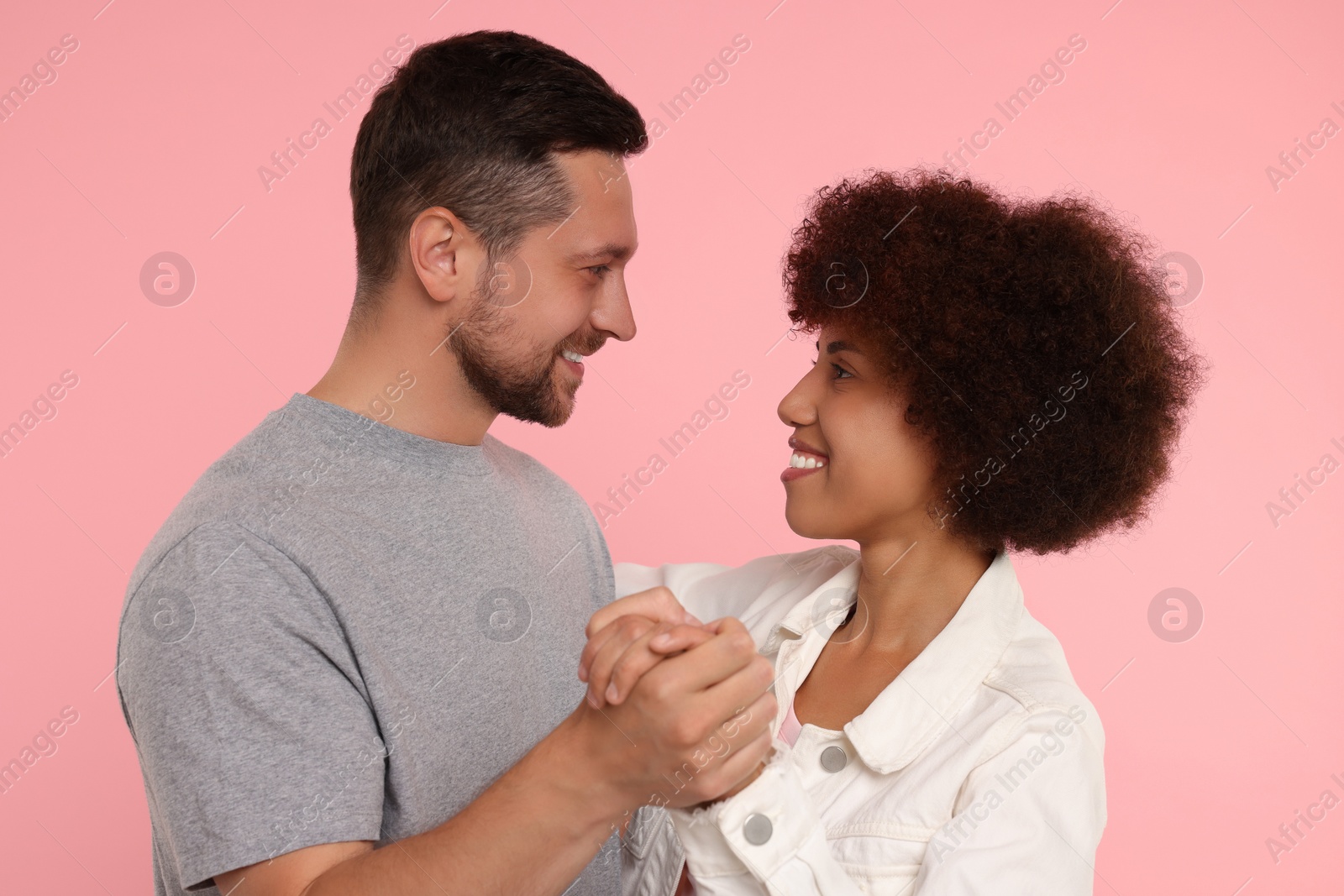 Photo of International dating. Happy couple dancing on pink background