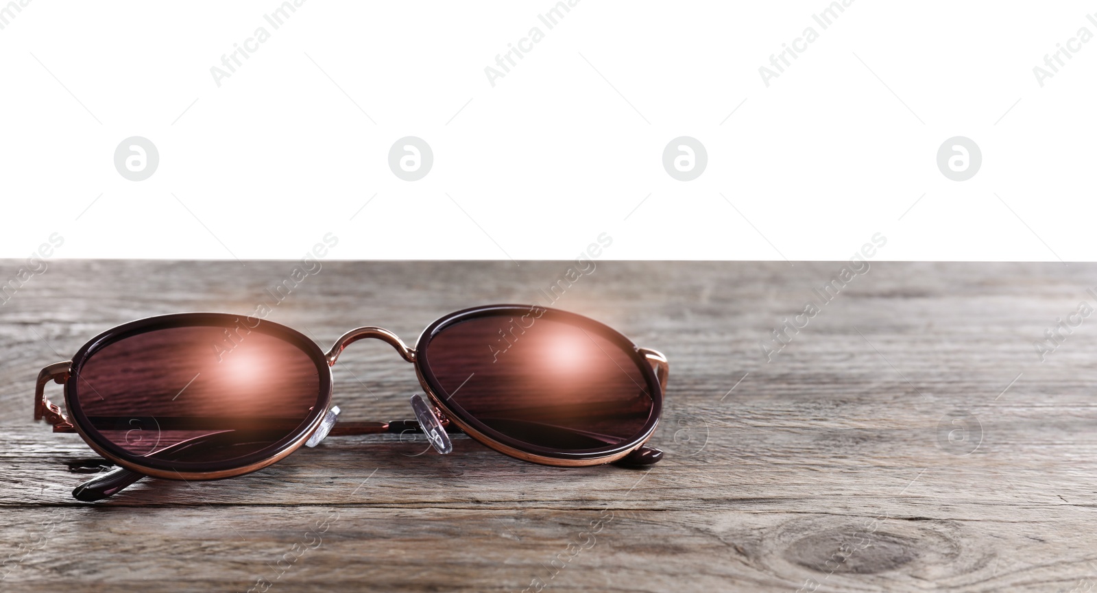 Photo of Stylish sunglasses on wooden table against white background. Space for text