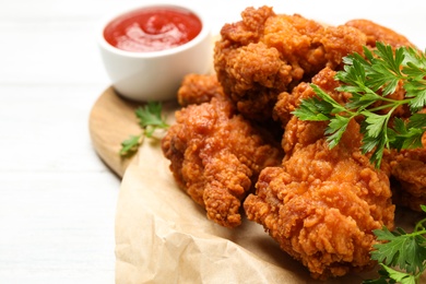 Photo of Tasty deep fried chicken pieces served on table, closeup