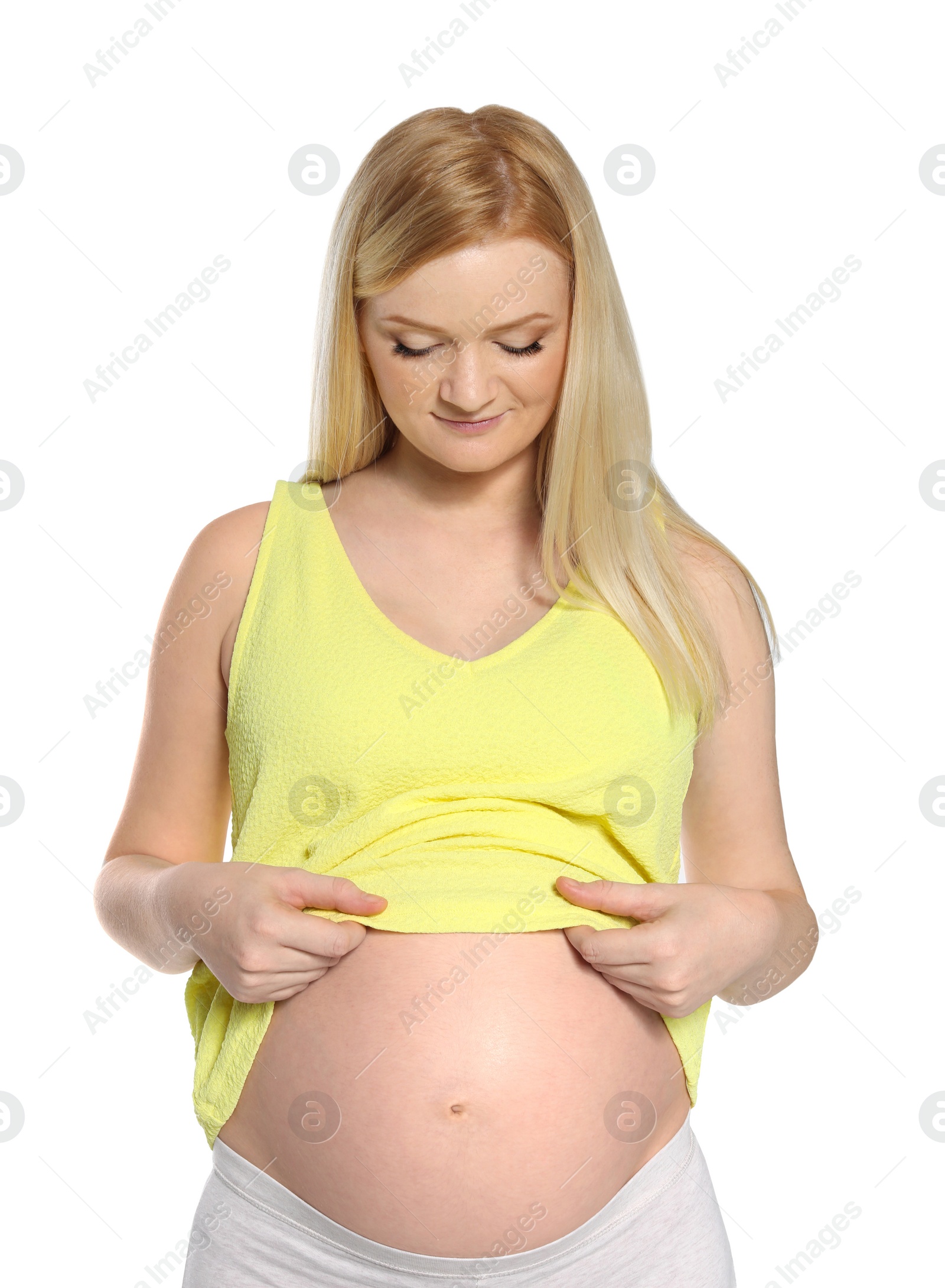 Photo of Beautiful pregnant woman showing her tummy on white background