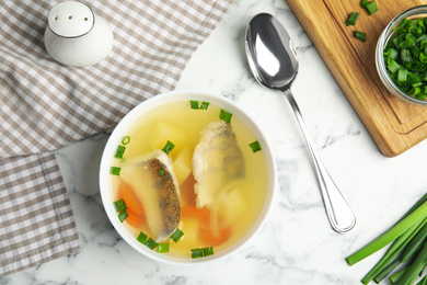 Photo of Delicious fish soup served on marble table, flat lay