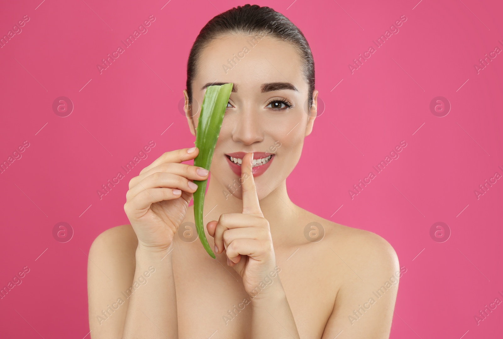 Photo of Young woman with aloe vera leaf on pink background