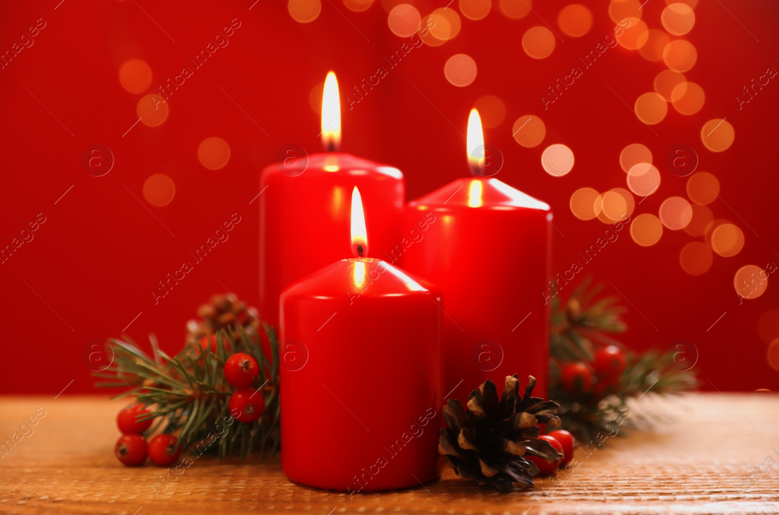 Photo of Beautiful Christmas composition with burning candles on wooden table against blurred lights