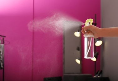 Photo of Woman spraying air freshener at home