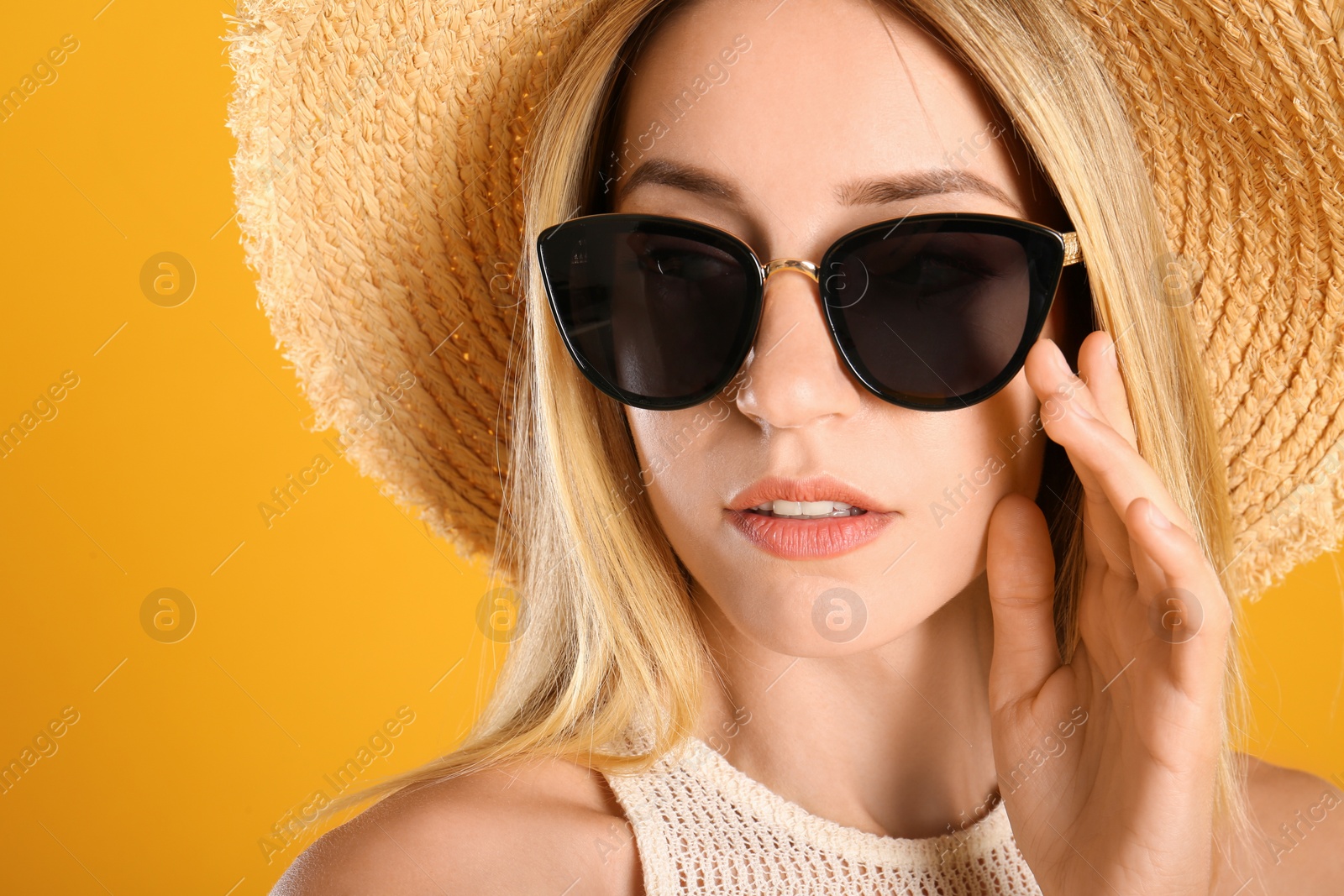 Photo of Beautiful woman in stylish sunglasses on yellow background, closeup