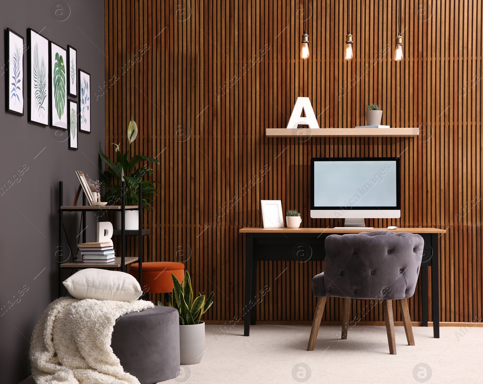 Photo of Comfortable workplace with computer near wooden wall in stylish room interior. Home office design