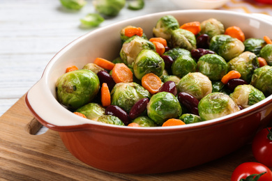 Photo of Roasted Brussels sprouts with beans and carrot in baking dish, closeup