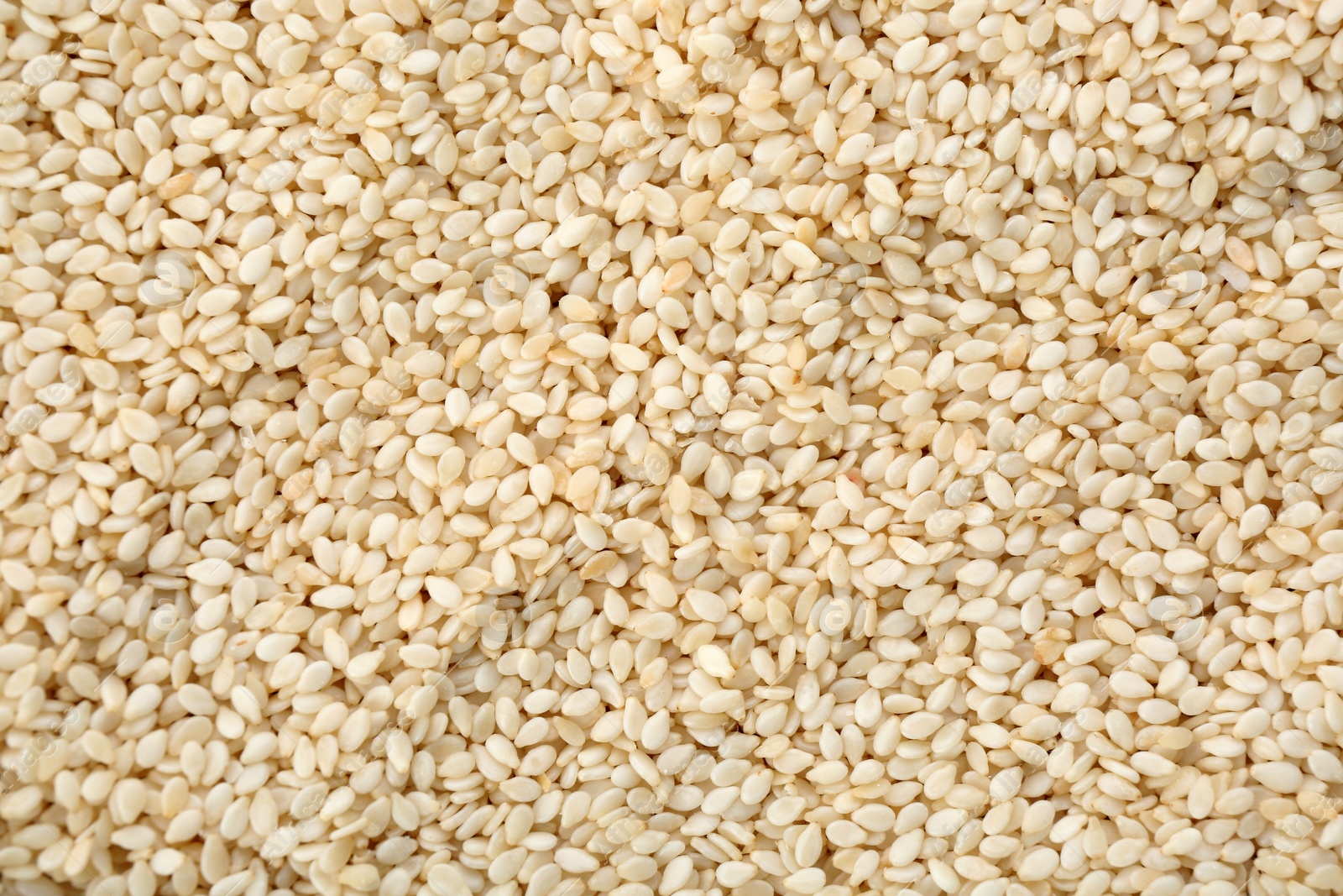 Photo of Pile of white sesame seeds as background, top view