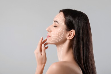 Image of Attractive woman with perfect skin after cosmetic treatment on grey background. Lifting arrows on her face
