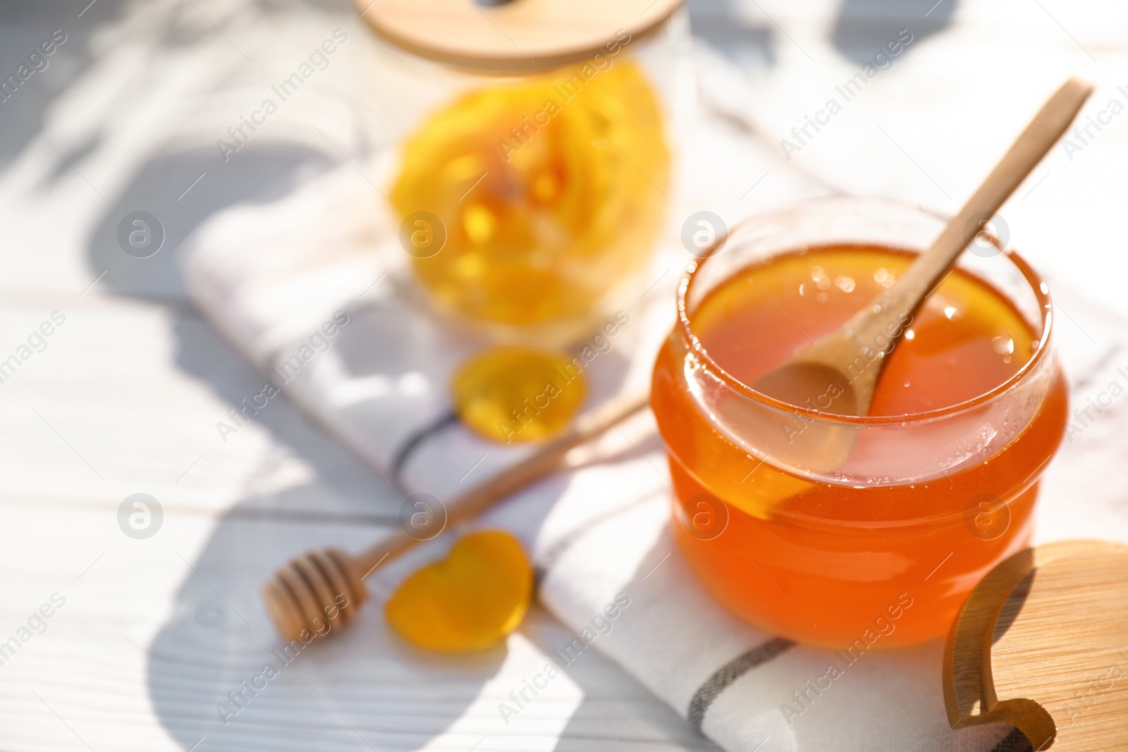 Photo of Composition with glass jar of fresh rose honey on white wooden table. Space for text