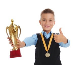 Photo of Happy boy in school uniform with golden winning cup and medal isolated on white