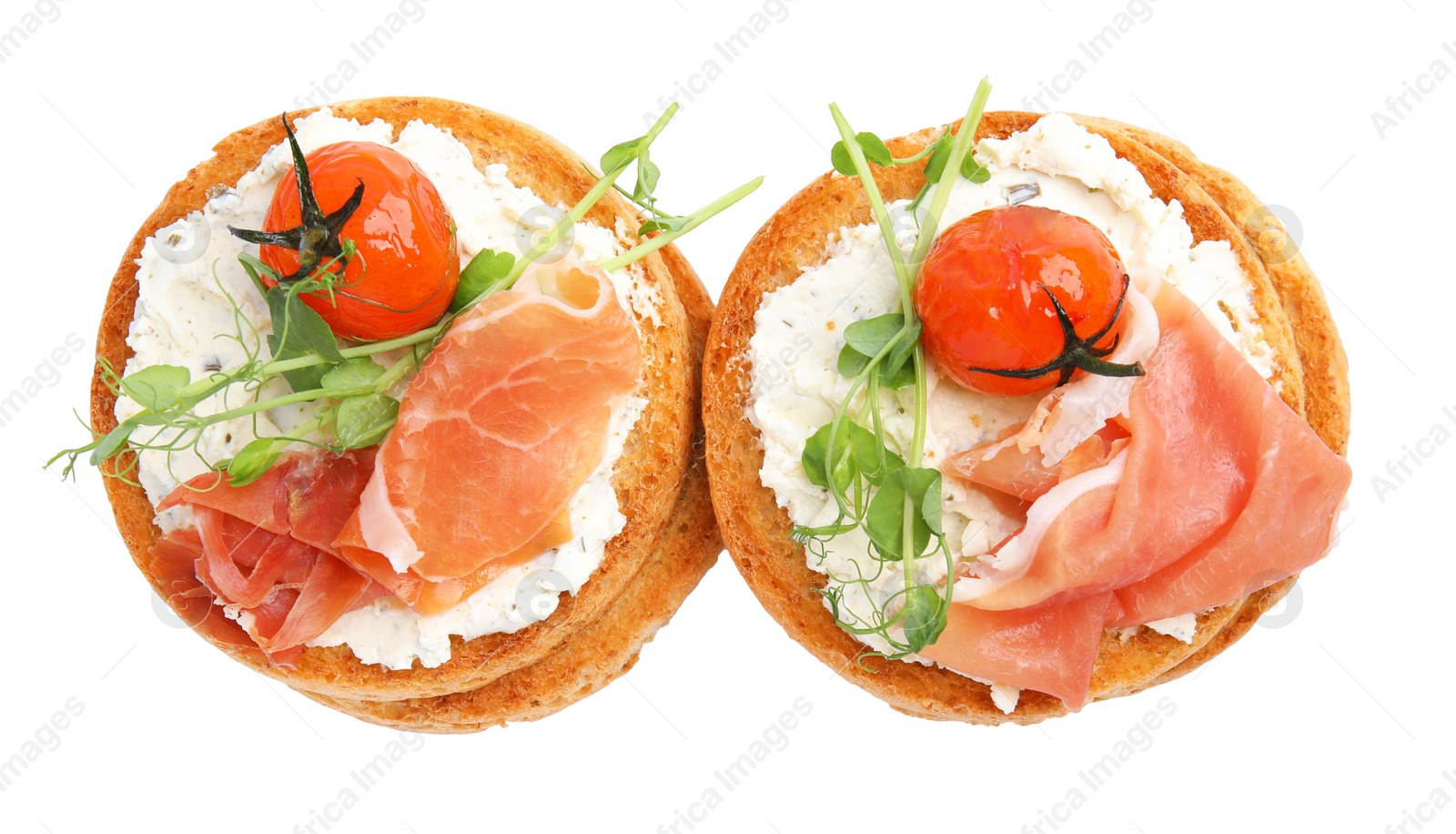 Photo of Tasty organic rusks with prosciutto, cream cheese and tomatoes on white background, top view