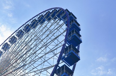 Photo of Amusement park. Beautiful Ferris wheel against blue sky, low angle view