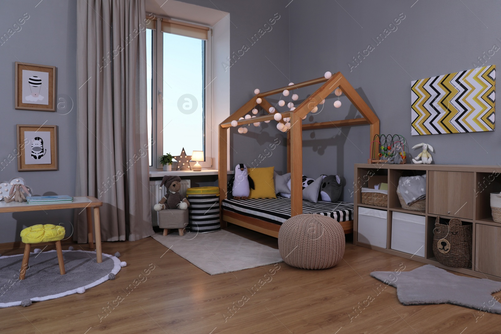 Photo of Stylish child room interior with comfortable house bed and toys