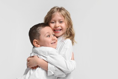 Photo of Cute little children hugging on white background. Happy family