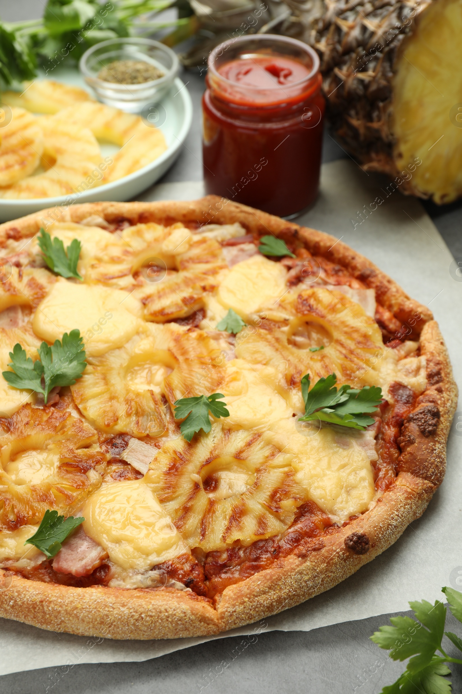 Photo of Delicious pineapple pizza with parsley on table