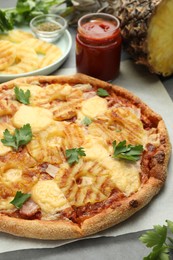 Photo of Delicious pineapple pizza with parsley on table