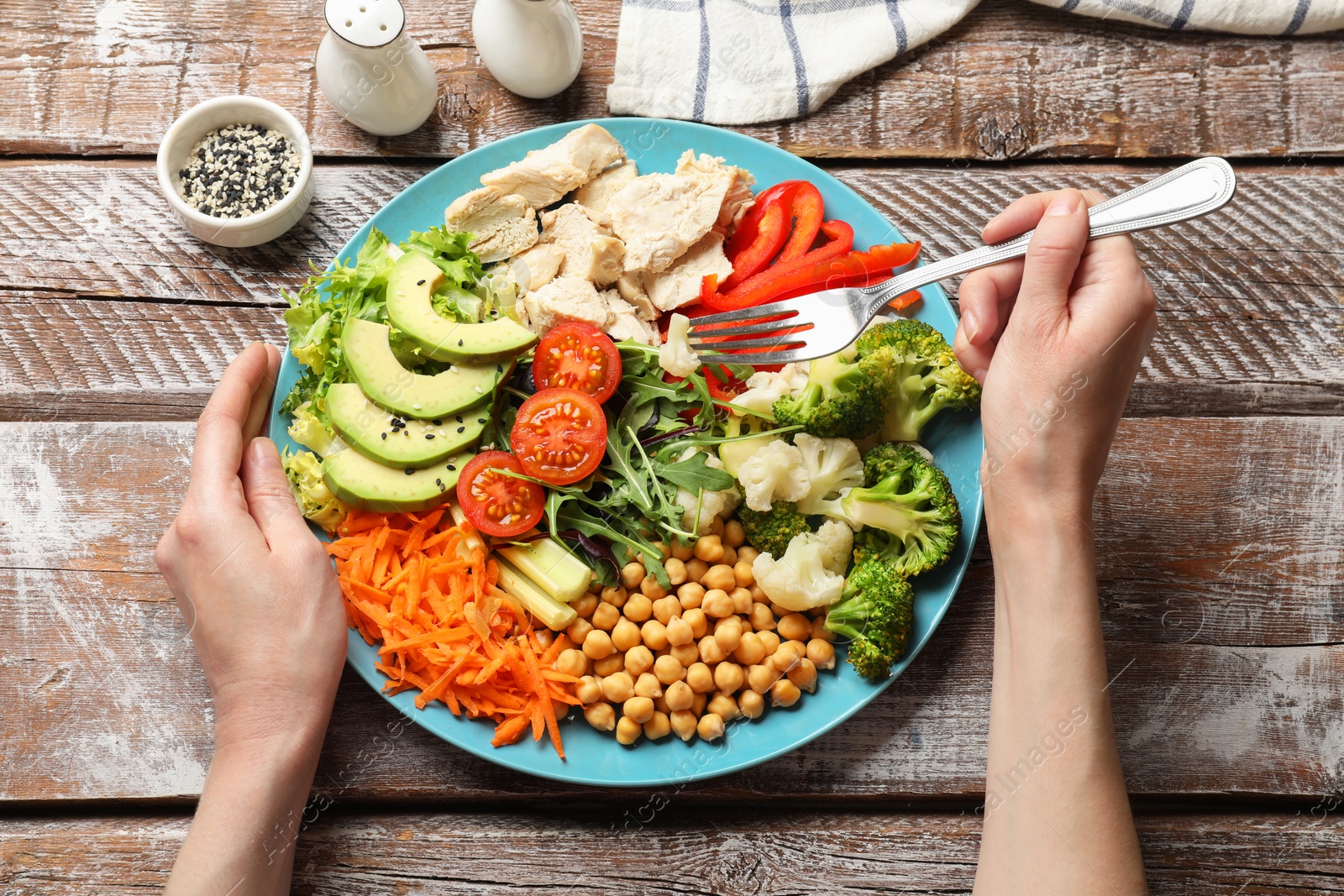 Photo of Balanced diet and healthy foods. Woman eating dinner at wooden table, top view