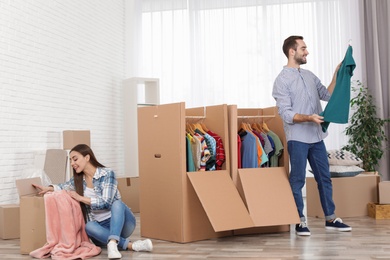 Photo of Young couple near wardrobe boxes at home