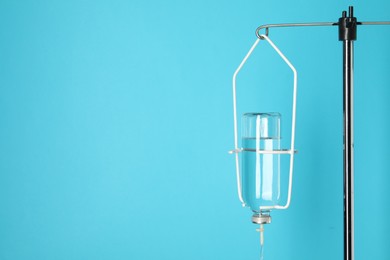 IV infusion set on pole against light blue background. Space for text