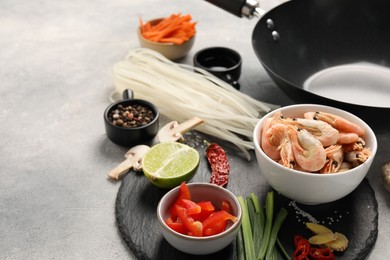 Photo of Different products and black wok on grey table, closeup