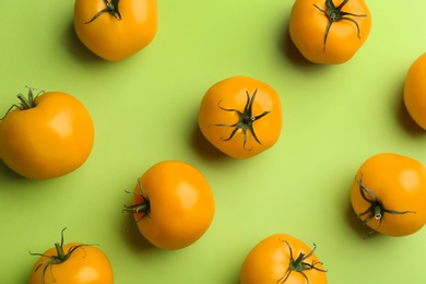 Photo of Yellow tomatoes on green background, flat lay