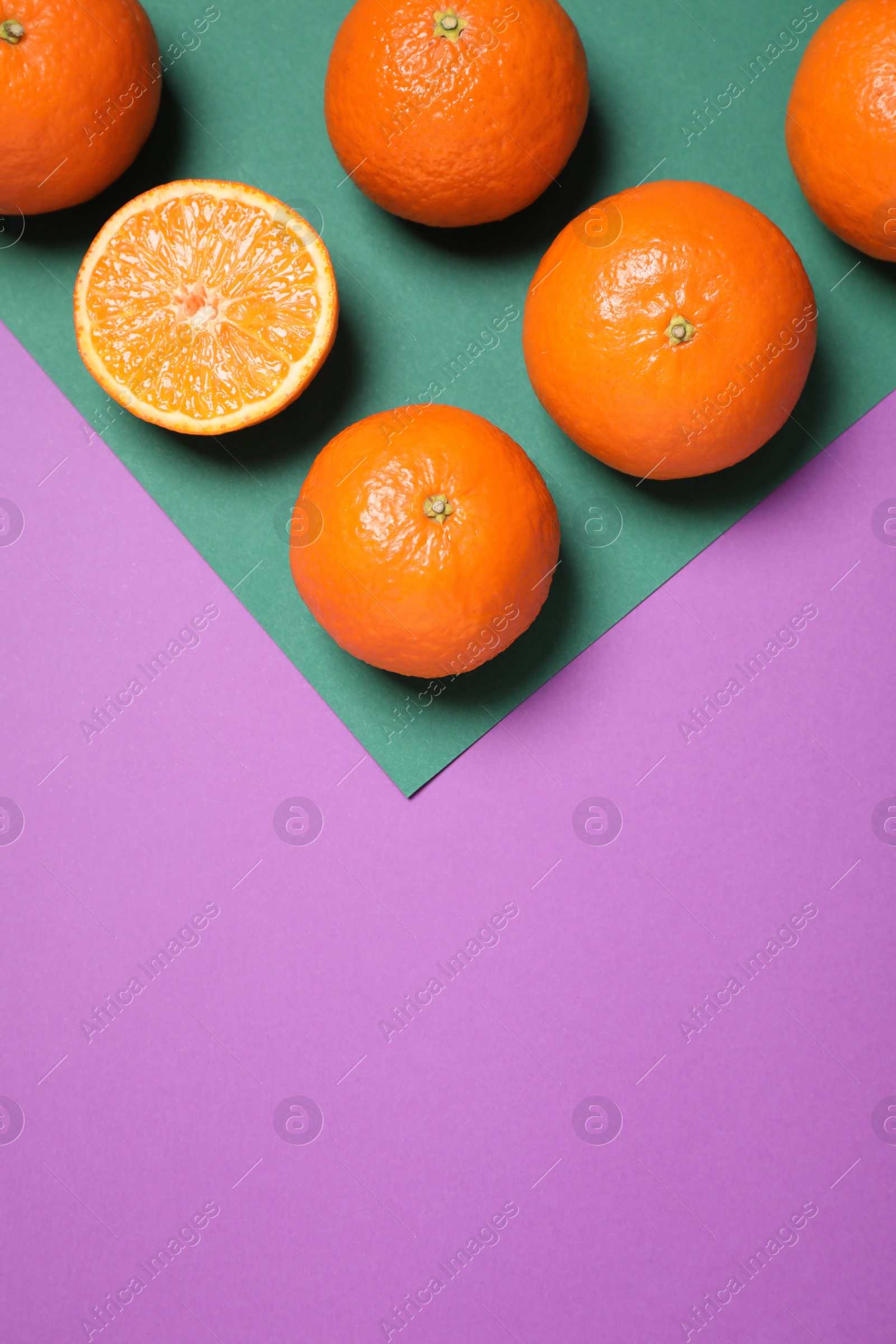 Photo of Fresh ripe tangerines on color background, flat lay. Space for text