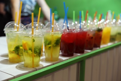 Photo of Plastic cups with refreshing drinks on bar counter