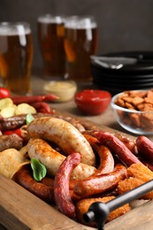Photo of Set of different tasty snacks and beer on wooden table, closeup view