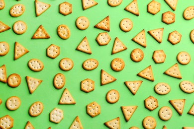 Photo of Delicious crackers on light green background, flat lay