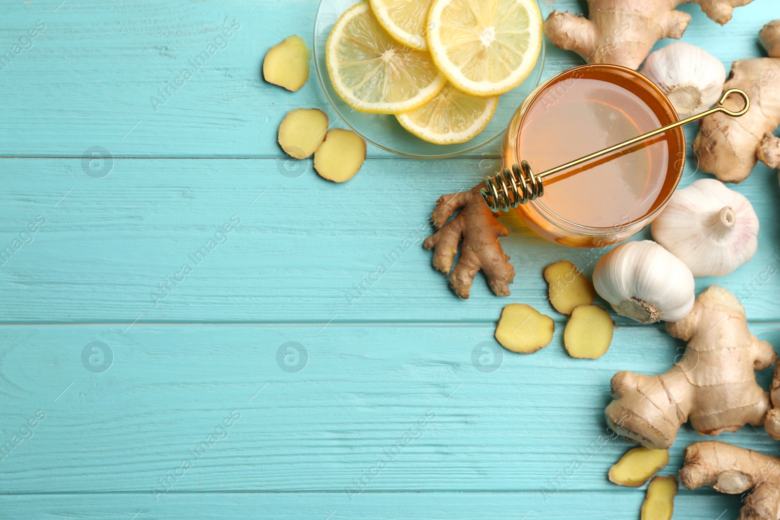 Photo of Ginger and other natural cold remedies on light blue wooden table, flat lay. Space for text