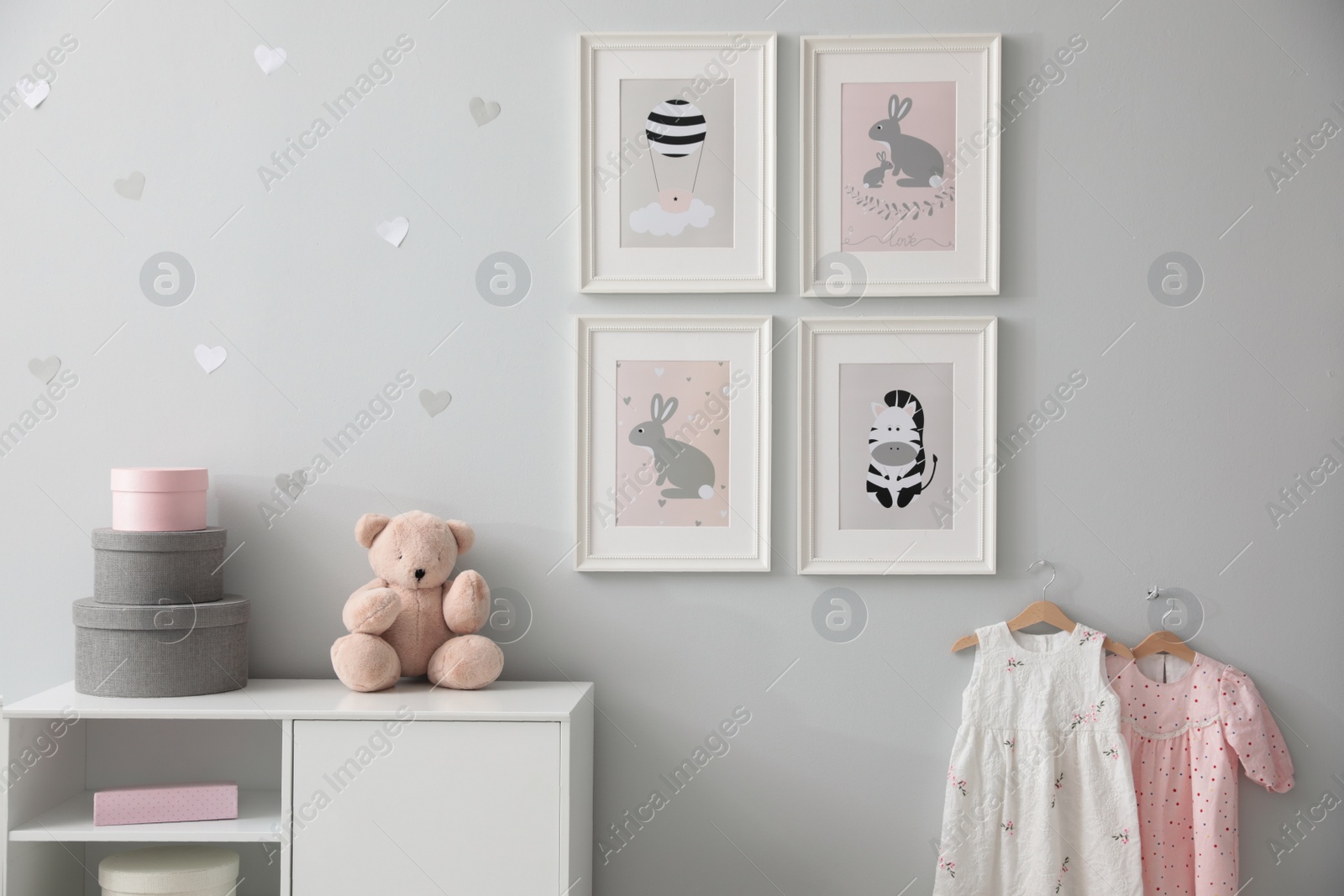 Photo of Stylish baby room interior with chest of drawers and cute pictures on wall