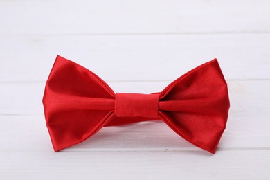 Photo of Stylish red bow tie on white wooden table