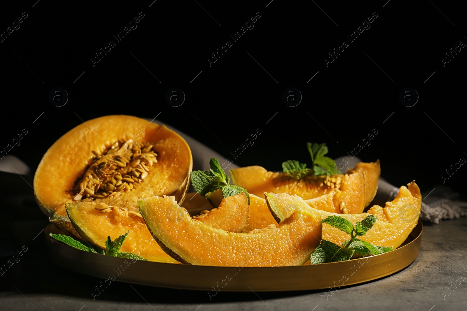 Photo of Freshly sliced ripe melon on table against black background