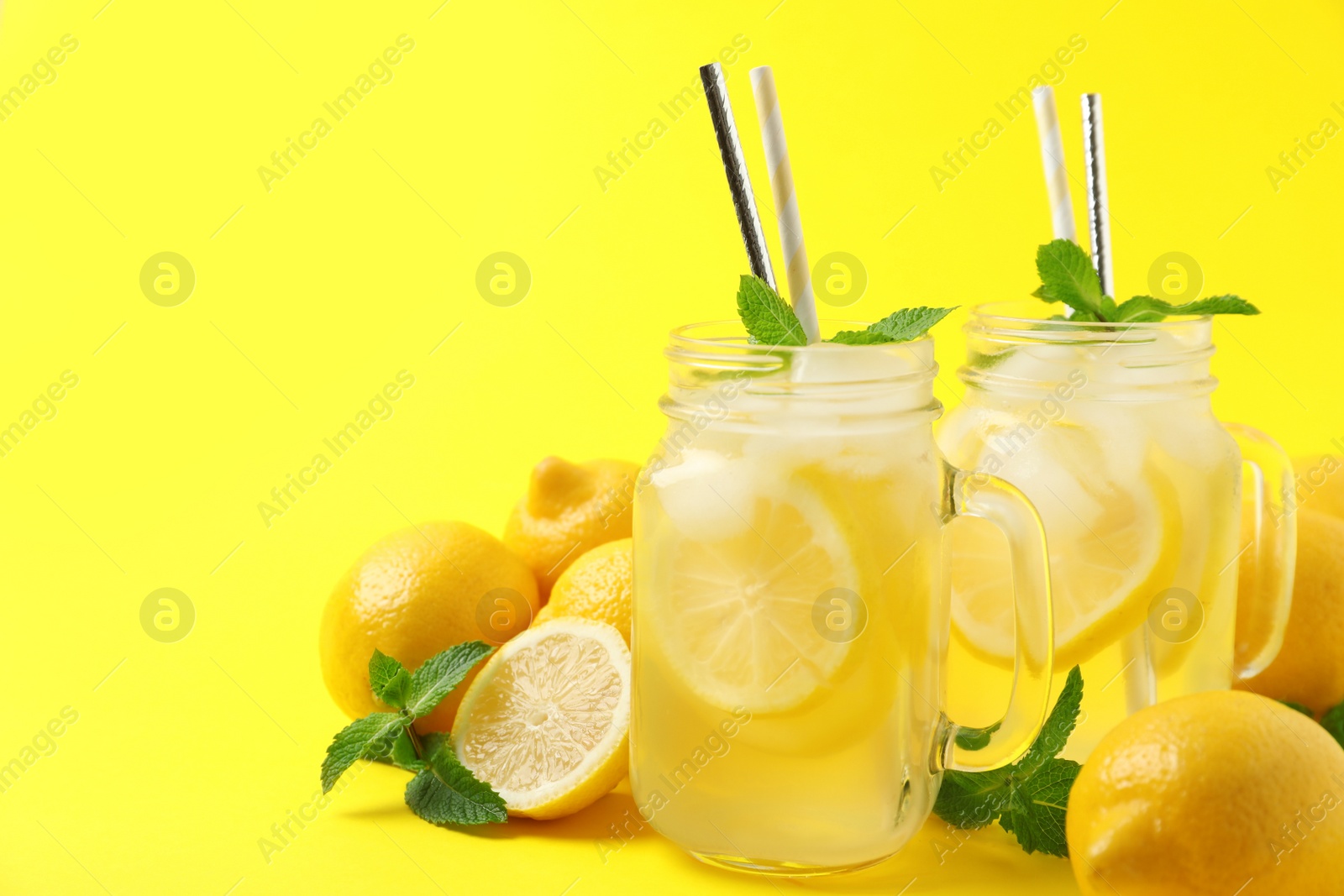 Photo of Freshly made natural lemonade on yellow background. Summer refreshing drink
