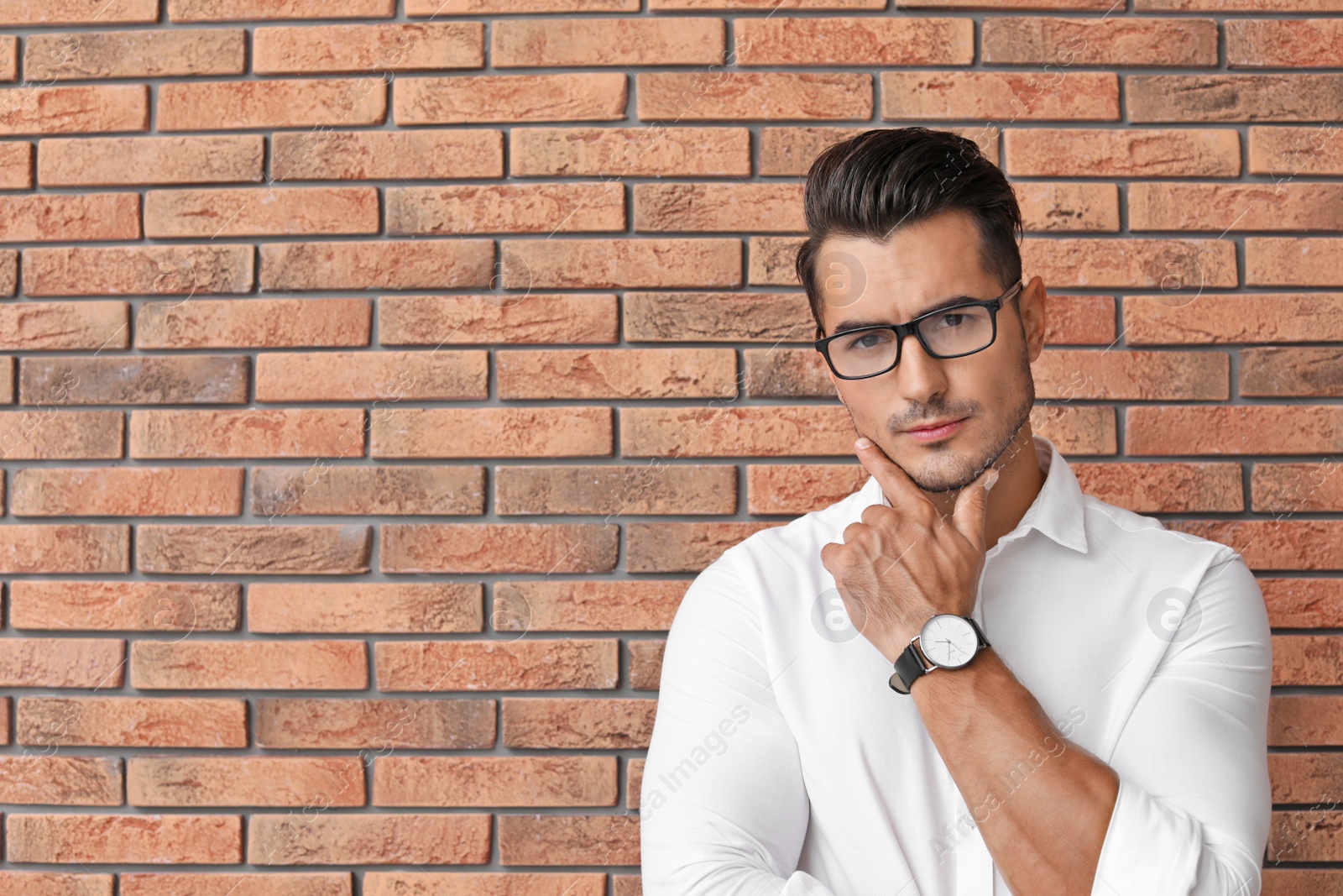 Photo of Portrait of handsome young man and space for text on brick wall background