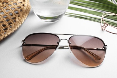 Photo of New stylish sunglasses on white table, closeup