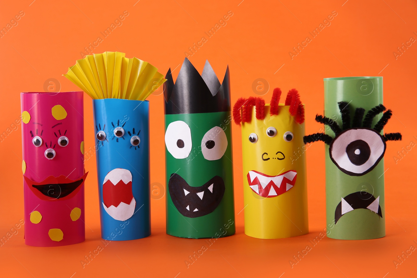 Photo of Funny monsters on orange background. Halloween decoration