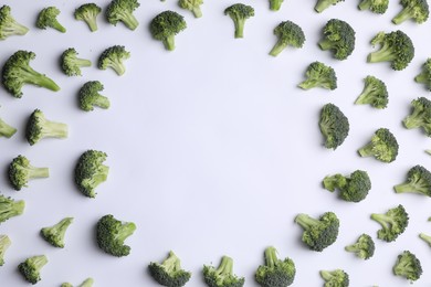 Photo of Frame made of many fresh green broccoli pieces on white background, flat lay. Space for text