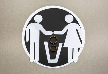 Divorce concept. Paper cutouts of couple, trash can and rings on light grey background, flat lay