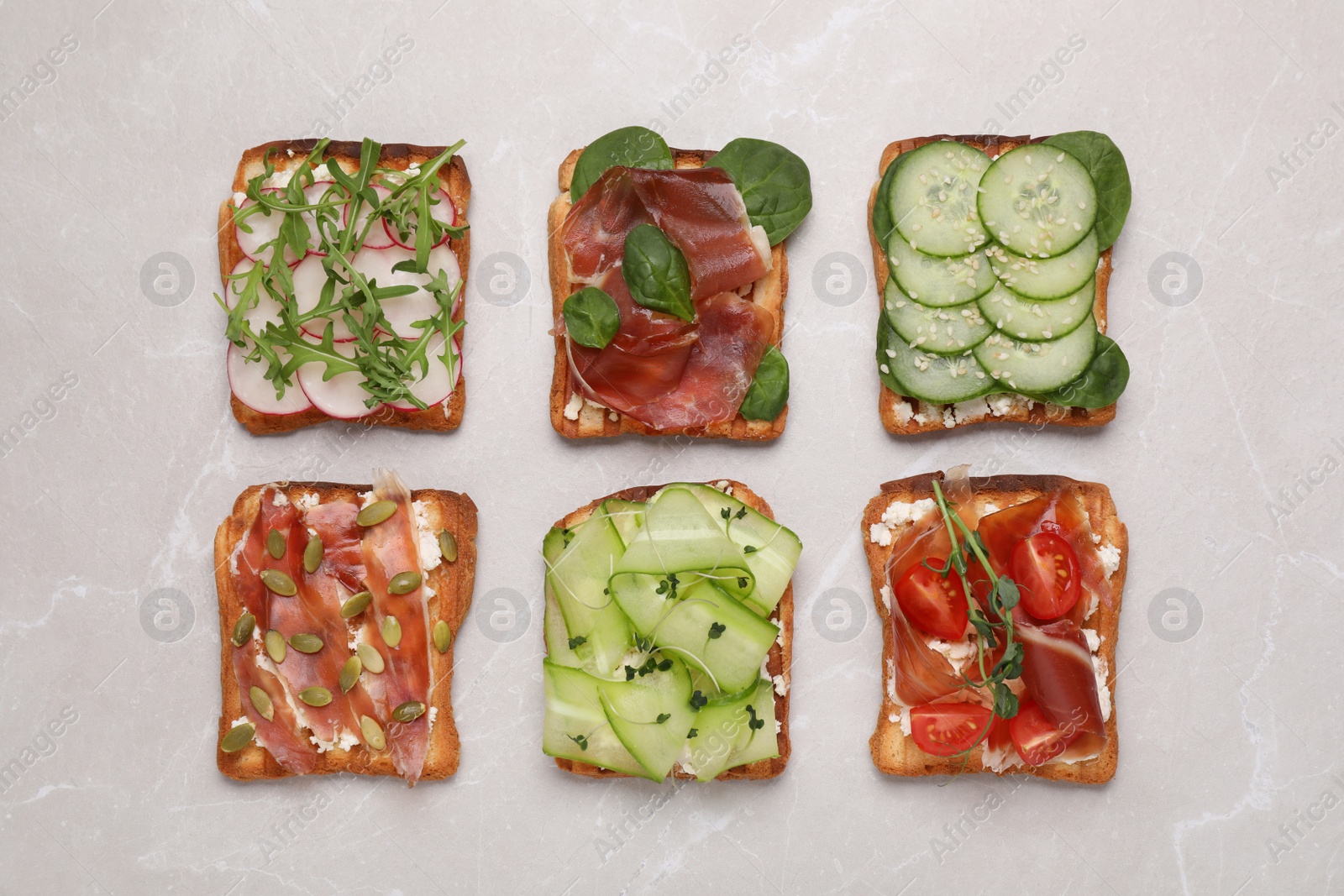 Photo of Different tasty sandwiches on light grey marble table, flat lay