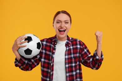 Photo of Happy fan with football ball on yellow background
