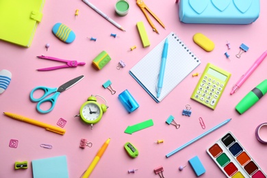 Photo of Bright school stationery on pink background, flat lay