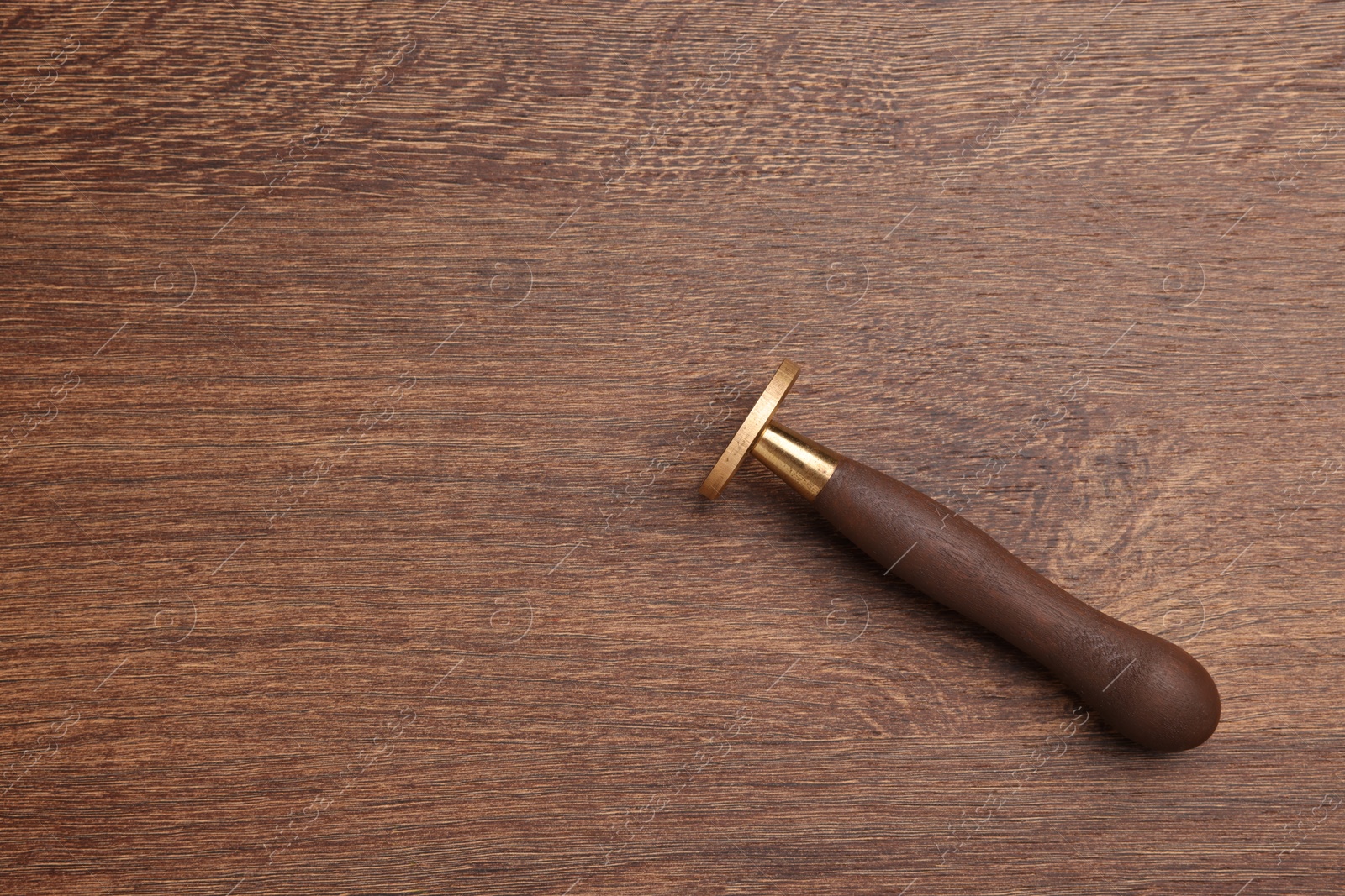 Photo of One stamp tool on wooden table, top view. Space for text