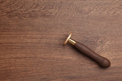 Photo of One stamp tool on wooden table, top view. Space for text