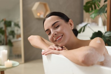 Photo of Beautiful young woman taking bubble bath at home